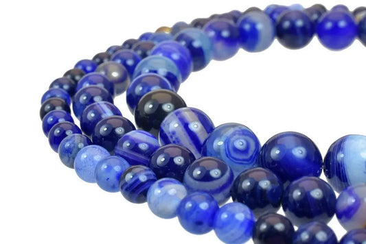 "Close-up of polished blue agate gemstone beads on a string"