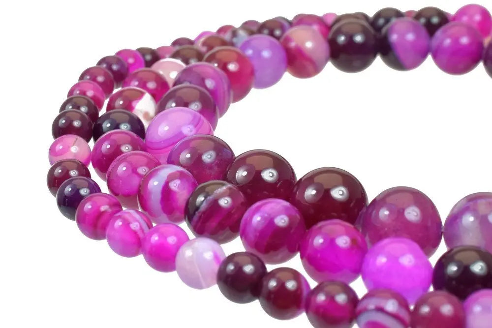 Polished pink agate gemstone beads necklace close-up.