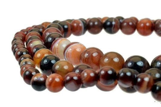 Close-up of brown agate bead necklace on white background.