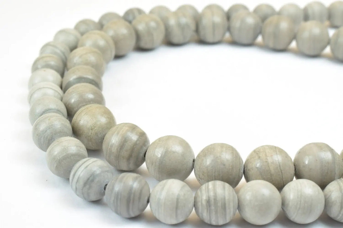 Gray marble bead necklace on white background.