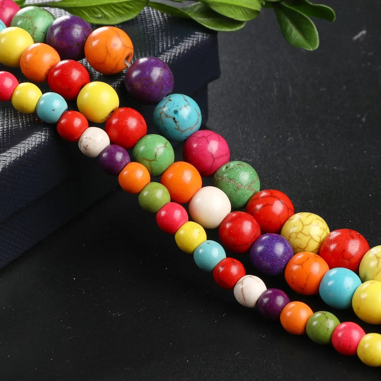 Colorful round stone beads for jewelry making on black background.