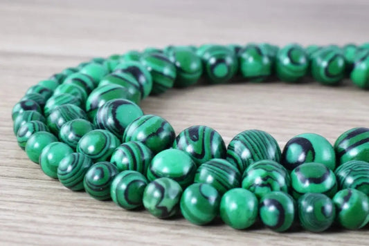 Green malachite stone beads necklace on wooden surface.