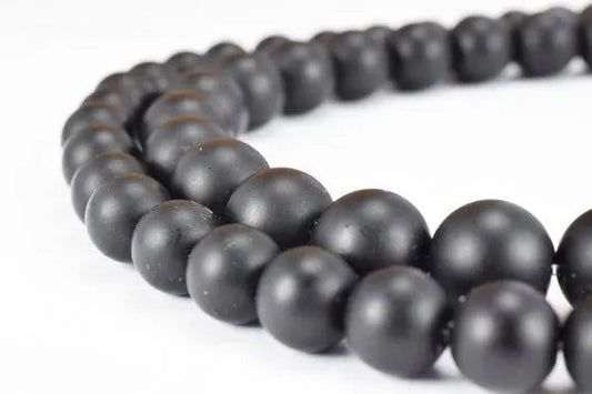 Black matte beaded necklace on white background.