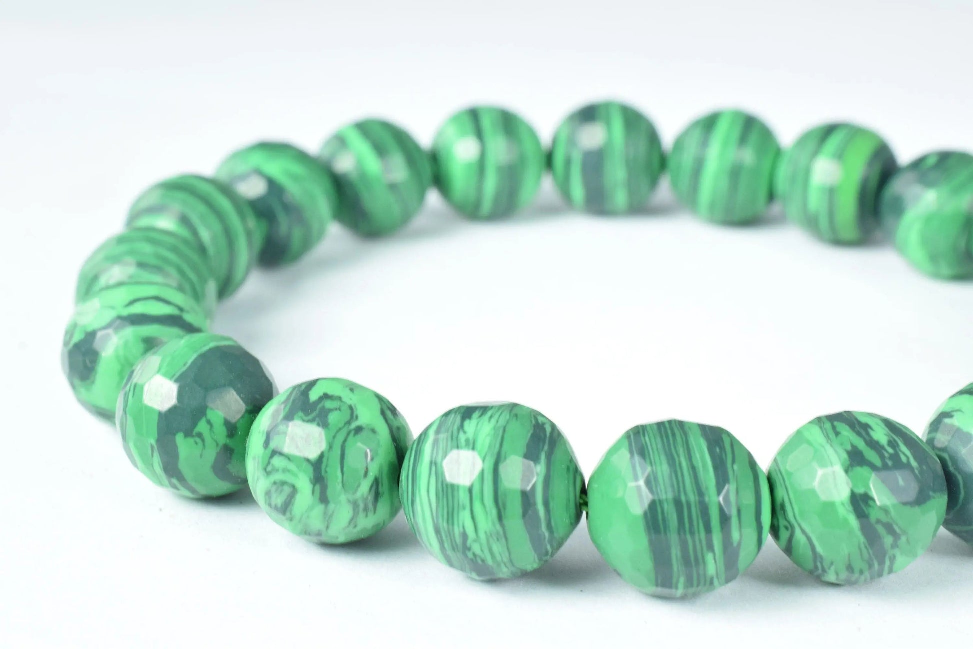 Green malachite beaded bracelet on white background.