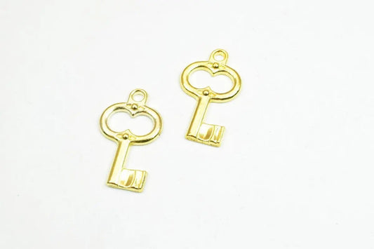 Golden skeleton key charms on a white background.