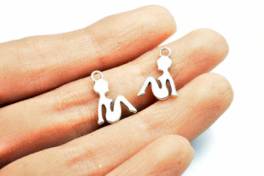 Silver silhouette woman charms on fingers.