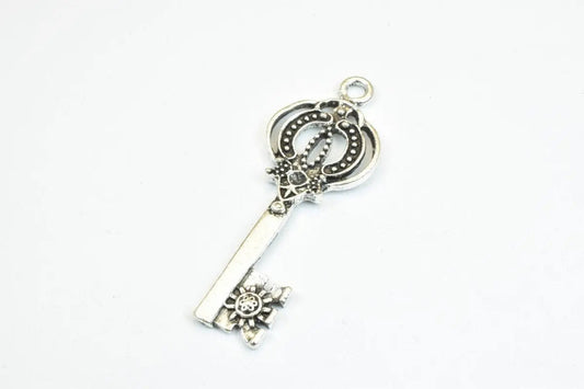 Silver ornate vintage-style skeleton key pendant on white background.