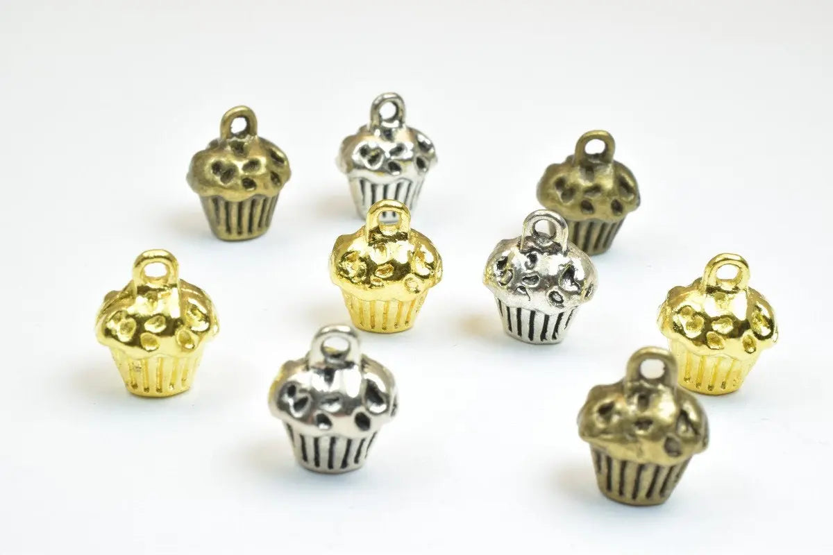 Cupcake-shaped metal charms in gold and silver for jewelry making.