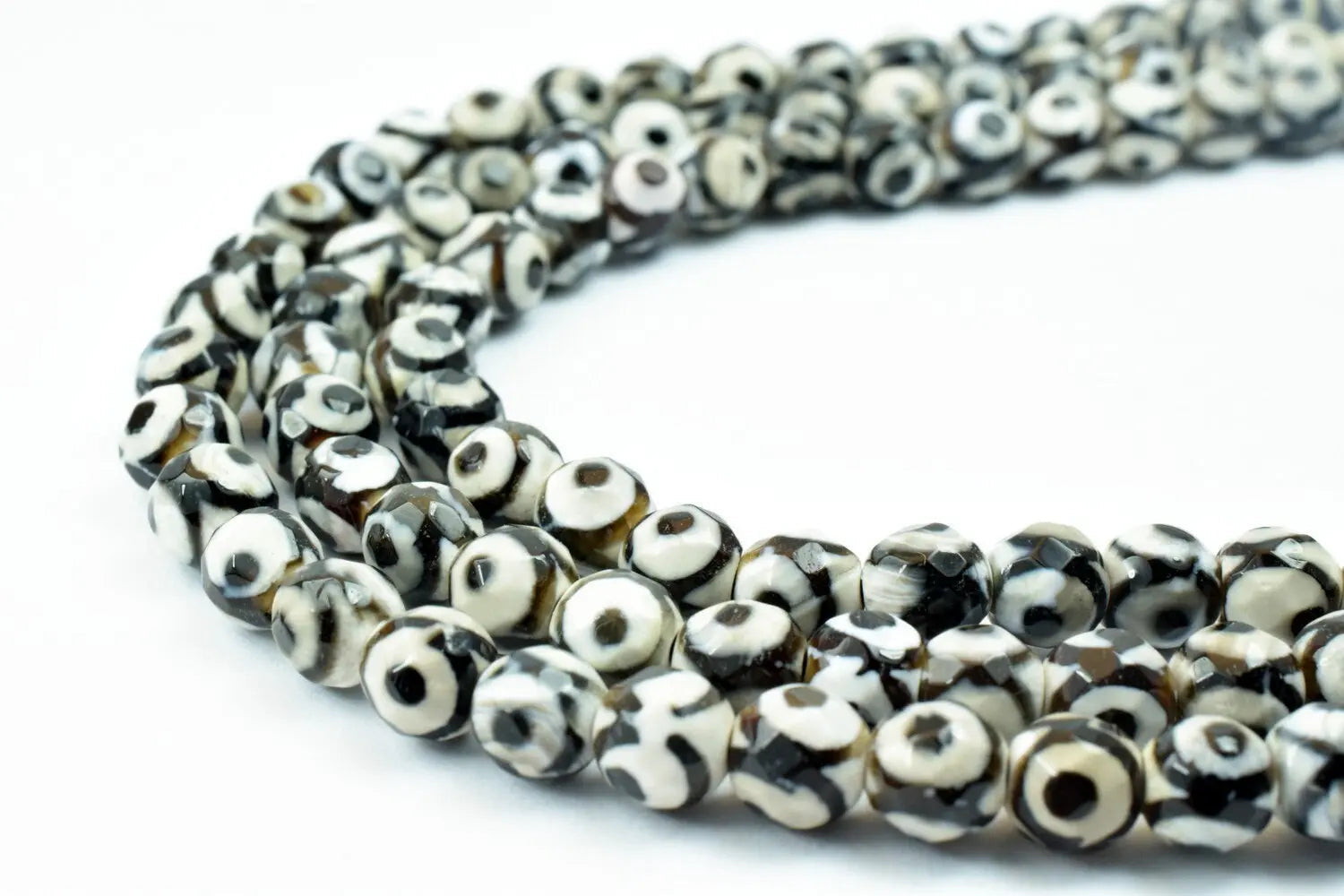 Black and white rondelle dzi beads necklace on white background.