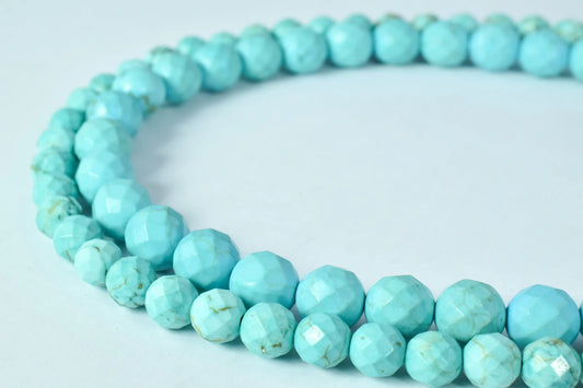 Turquoise faceted bead necklace on white background.