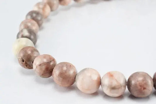 "Natural pink jasper gemstone bead bracelet on white background"