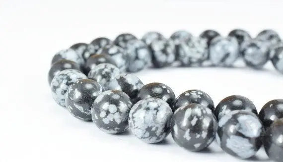 Snowflake obsidian bead bracelet close-up on white background.