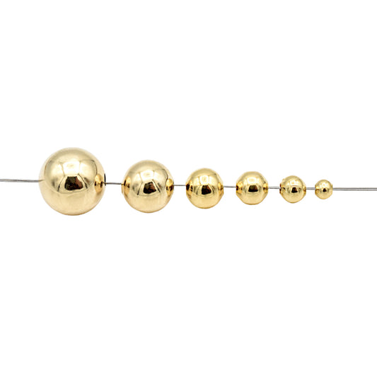 Gold metal beads in graduated sizes on a string.