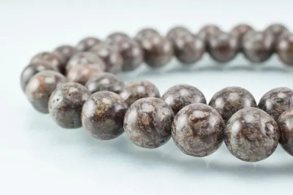 Polished brown jasper stone bead necklace on a white background.