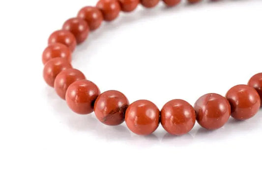 Red jasper beaded bracelet on white background.