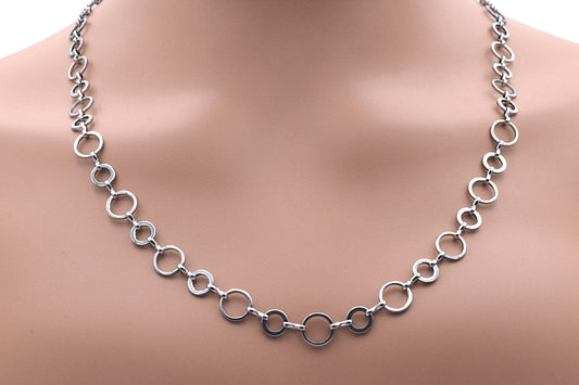 Silver circle link chain necklace on display mannequin.