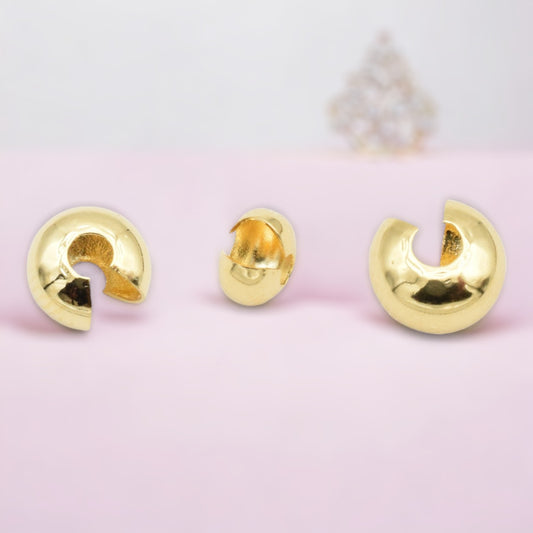 Gold chunky hoop earrings on pink background.