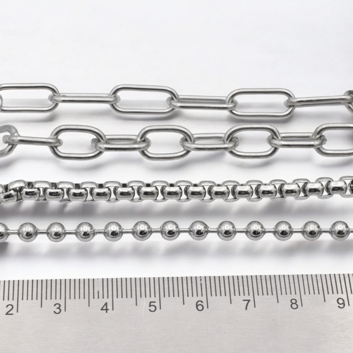 "Variety of silver chains with ruler for size reference"