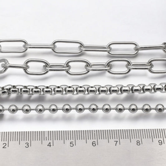 "Variety of silver chains with ruler for size reference"