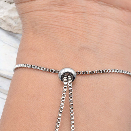 "Adjustable silver-tone bracelet on wrist with sliding clasp"