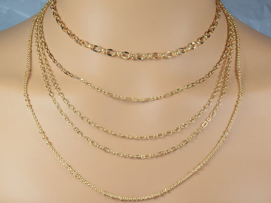 Layered gold chain necklace on mannequin bust.