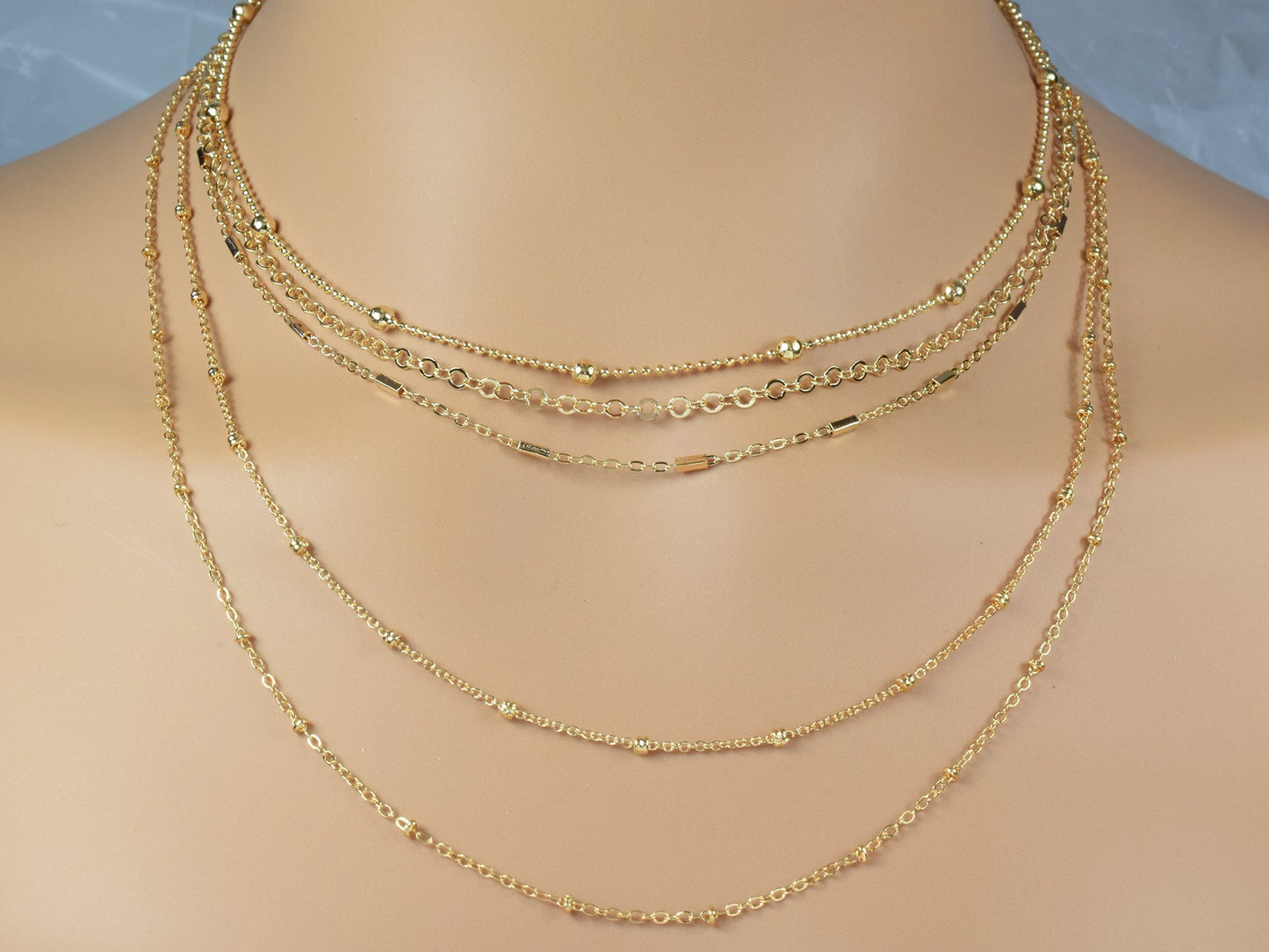 "Layered gold chain necklace on display"