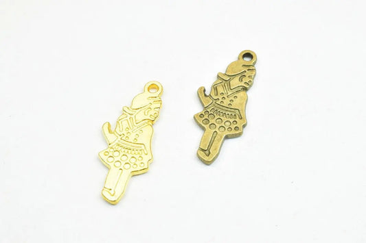 Gold and bronze girl-shaped jewelry charms on white background.