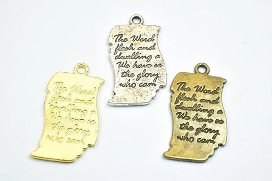 Three engraved metal pendants with text, in gold, silver, and brass finishes.