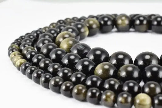 Black and gold obsidian bead necklaces on white background.