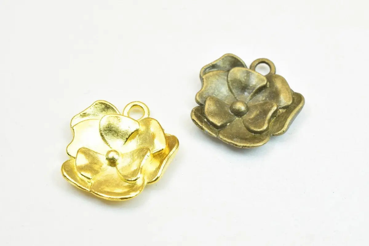 Gold and bronze flower-shaped metal charms for jewelry making.