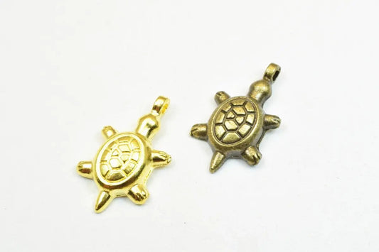 Gold and bronze turtle pendants on white background.