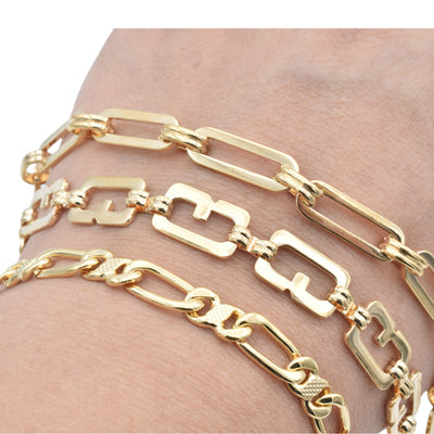 Gold chain link bracelets on wrist.