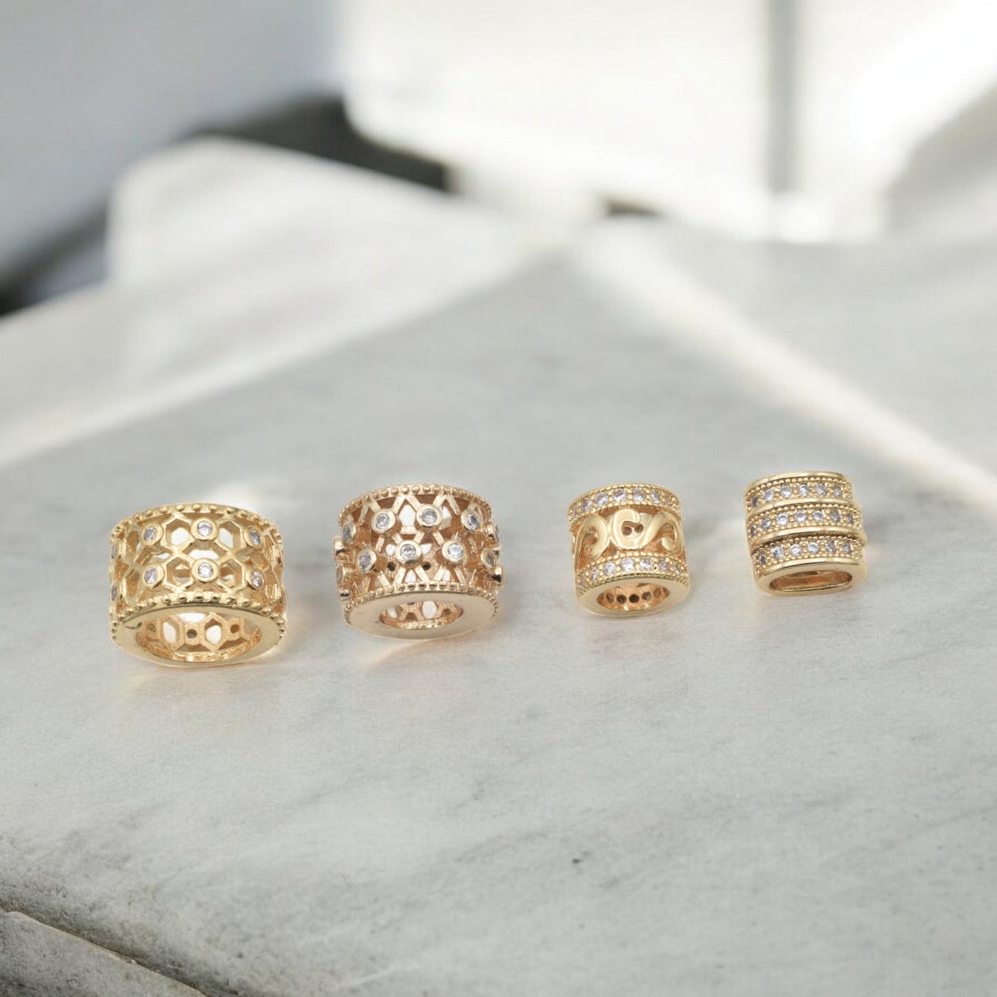 Gold and diamond ornate ring set displayed on marble surface.