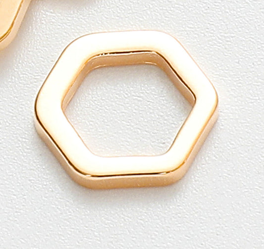 Hexagonal gold metal decor on white background.