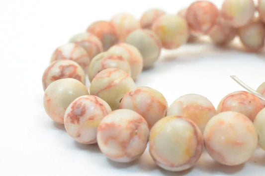 Warm-toned marble beads strung on a white background.