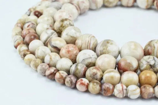 Multicolor round gemstone beads for jewelry making on white background.