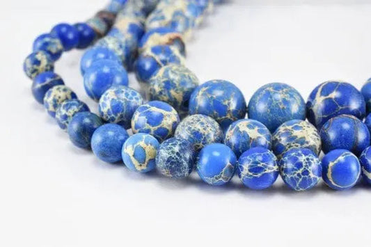 Blue marbled stone beads necklace on white background.