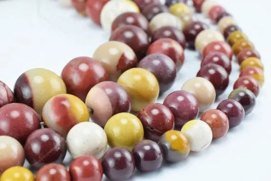 Multicolor stone bead necklace close-up on white background.