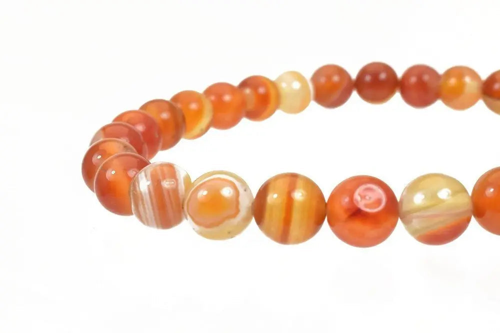 Red agate beaded bracelet on white background.