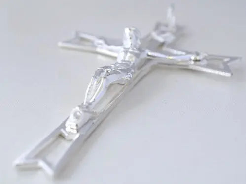 Silver crucifix pendant on white background.
