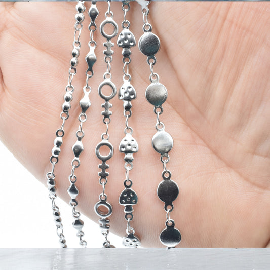 Silver charm necklace chains with unique geometric designs.