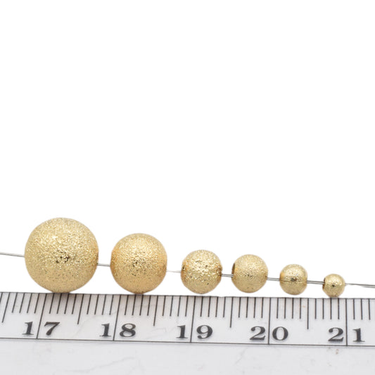 "Set of textured gold spacer beads on a measuring scale"