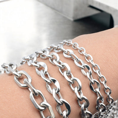 Silver chain bracelets on wrist, close-up view.