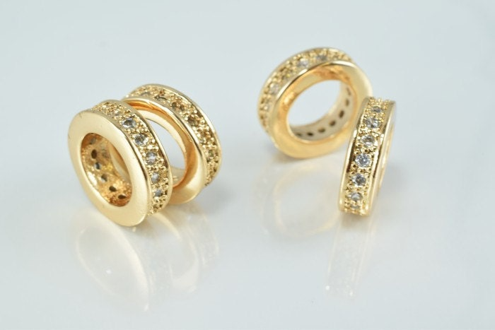 Gold diamond-studded hoop earrings on white background.