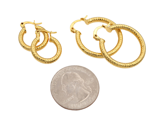 Gold hoop earrings with textured design next to a US quarter for size reference.