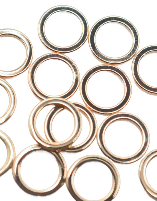 Gold metal washers arranged on a white background.