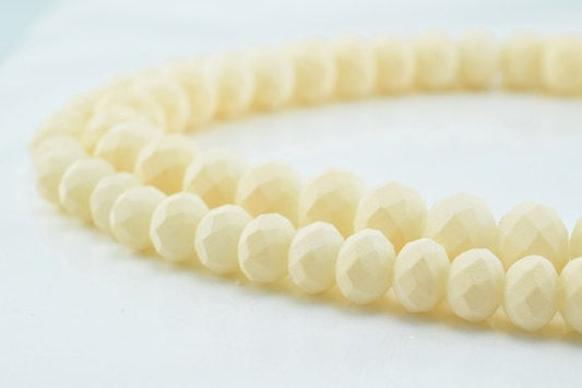 Cream faceted bead necklace on white background.