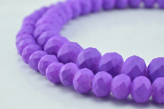 Purple faceted bead necklace close-up on white background.