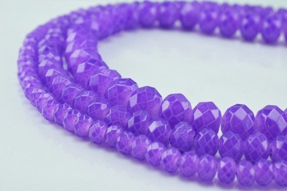 Purple faceted gemstone beads necklace on white background.