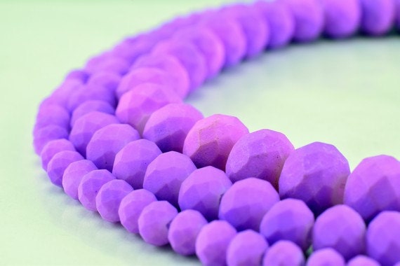 "Faceted purple gemstone bead necklace on light background"